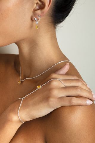 Close up of yellow stone jewelry set, including yellow pear shape stone hand chain