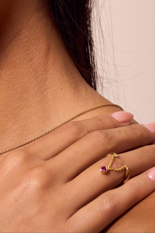 Gold ring with red gemstone close up.

Anillo dorado con gema roja en primer plano