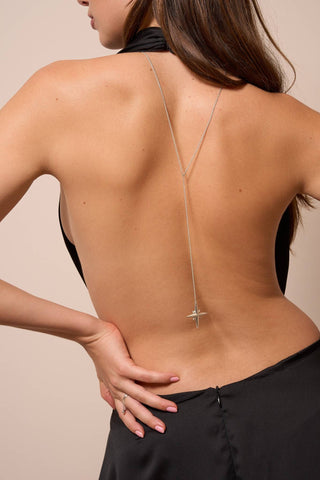 Model wearing the Noema back necklace in silver, the star-shaped pendant resting elegantly along the back.

Modelo usando el collar de espalda Noema en plata, con el dije en forma de estrella descansando elegantemente en la espalda.